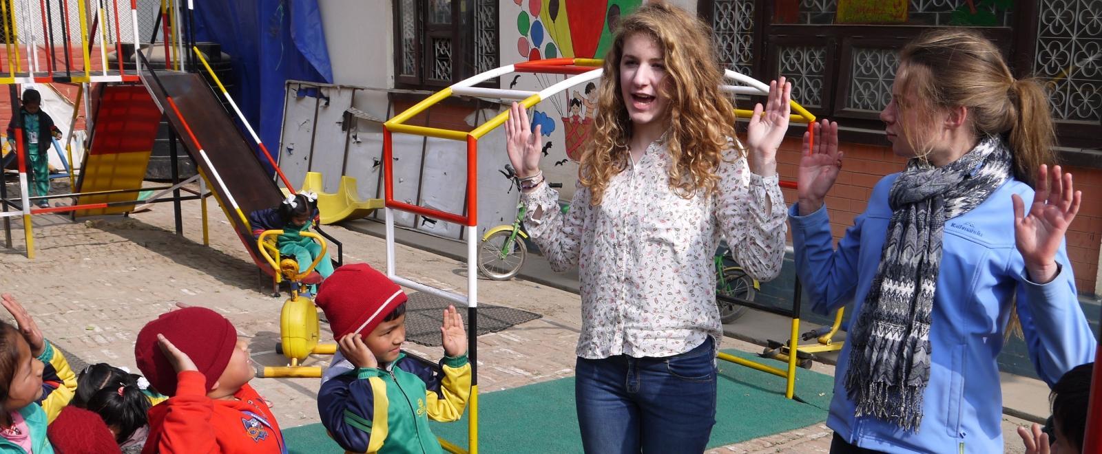 Two teen volunteers running outdoor activities for school children